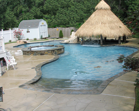Pool with beach entrance, pool bar, and waterfall feature